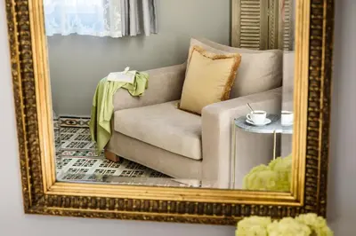 a living room with a mirror and a couch at Mosaic in Chania Town
