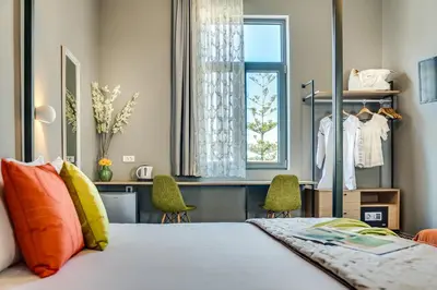 a bedroom with a bed and a window and chairs at Mosaic in Chania Town