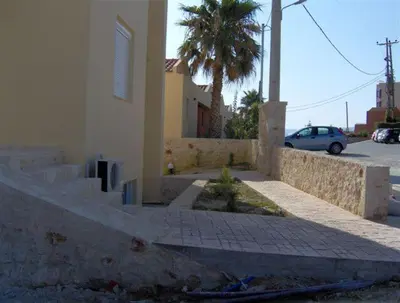 a street with a building and a palm tree at Blue Villas in Agia Marina Nea Kydonias