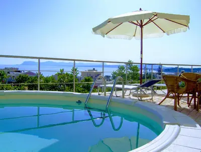 a swimming pool with an umbrella and a table and chairs at Blue Villas in Agia Marina Nea Kydonias