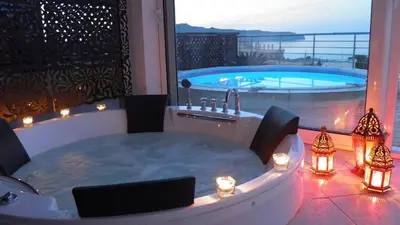 a jacuzzi tub on a balcony with a pool at Blue Villas in Agia Marina Nea Kydonias