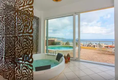 a bathroom with a tub with a view of the ocean at Blue Villas in Agia Marina Nea Kydonias