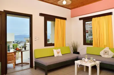 a living room with two couches and a table at Mythos- Platanias- Hotel -Apts in Plataniás