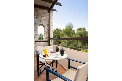 a balcony with a table and chairs on a balcony at Talos Hotel Apartments in Kato Daratso