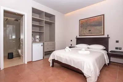 a bedroom with a large bed and a bathroom at Talos Hotel Apartments in Kato Daratso