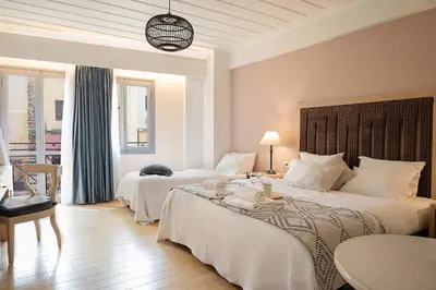 a hotel room with two beds and a table at Vranas Ambiance Hotel in Chania Town