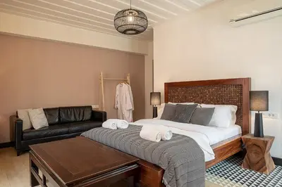 a bedroom with a large bed and a couch at Vranas Ambiance Hotel in Chania Town
