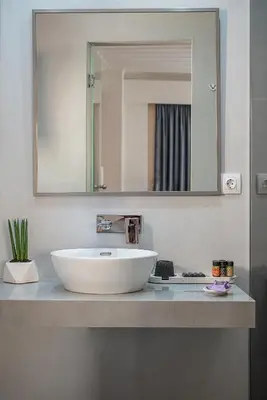 a bathroom with a white sink and a mirror at Vranas Ambiance Hotel in Chania Town