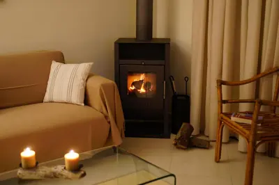 a living room with a couch and a fireplace with two candles at Chryssi myHome in Kato Daratso