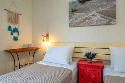 a bedroom with two beds and a red night stand at Chryssi myHome in Kato Daratso