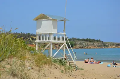 a lifeguard tower on a beach with people in the water at Chryssi myHome in Kato Daratso