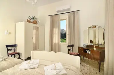 a white room with a bed and a mirror at Haralabos Central Apartment in Chania Town