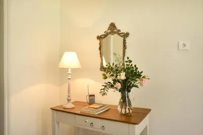 a table with a vase of flowers and a mirror at Haralabos Central Apartment in Chania Town