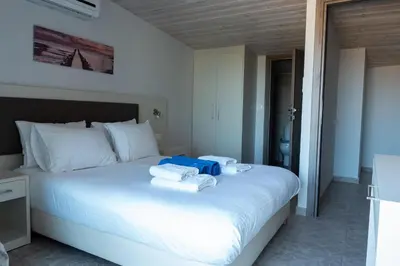 a bedroom with a white bed with towels on it at Enali Villas in Kissamos