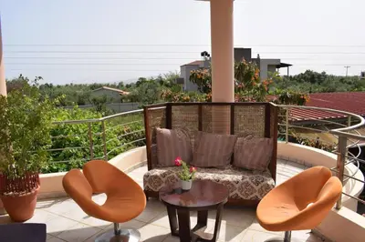 a balcony with a couch and two chairs and a table at ILIAS VILLA IN CHANIA in Perivólia