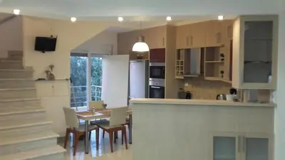 a kitchen and dining room with a table and chairs at ILIAS VILLA IN CHANIA in Perivólia