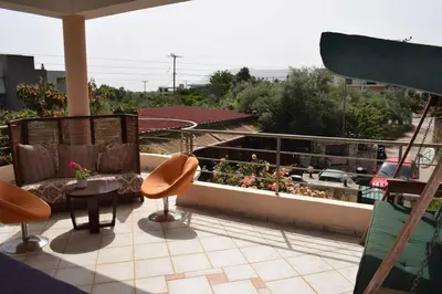 a balcony with chairs and a table and some plants at ILIAS VILLA IN CHANIA in Perivólia