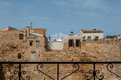 an old stone wall with buildings in the background at Spolia Art Maison in Chania Town