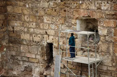 a man standing on a scaffolding in front of a brick wall at Spolia Art Maison in Chania Town