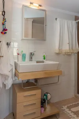 a bathroom with a white sink and a mirror at Spolia Art Maison in Chania Town