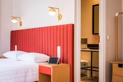 a bedroom with a bed with a red headboard at TheJoy City Suites in Chania Town