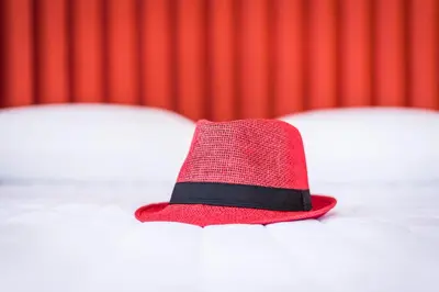 a red hat sitting in front of a red curtain at TheJoy City Suites in Chania Town