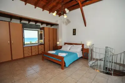 a bedroom with a blue bed and a window at Romantic Corner Maisonette houses in Stalos