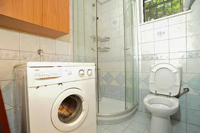a bathroom with a washing machine and a toilet at Romantic Corner Maisonette houses in Stalos