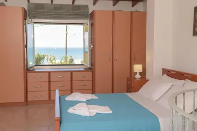 a bedroom with a bed with a view of the ocean at Romantic Corner Maisonette houses in Stalos