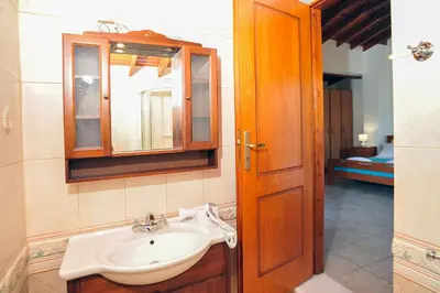 a bathroom with a sink and a mirror and a door at Romantic Corner Maisonette houses in Stalos