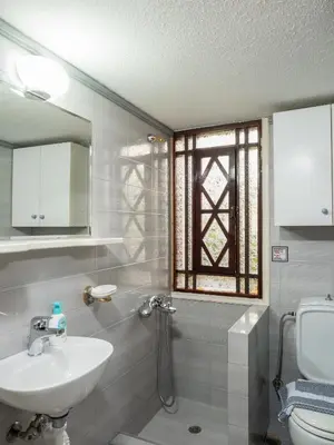 a bathroom with a sink and a toilet and a window at Romantic Corner Maisonette houses in Stalos