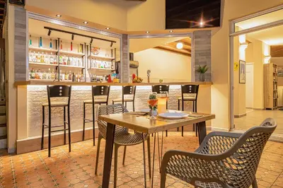 a bar with chairs and a table in a restaurant at Theos Village Apartments in Kato Daratso