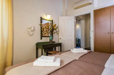 a bedroom with two beds and a mirror and a table at Theos Village Apartments in Kato Daratso