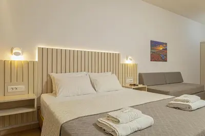 a bedroom with a large bed with towels on it at Theos Village Apartments in Kato Daratso