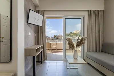 a hotel room with a bed and a balcony at Theos Village Apartments in Kato Daratso