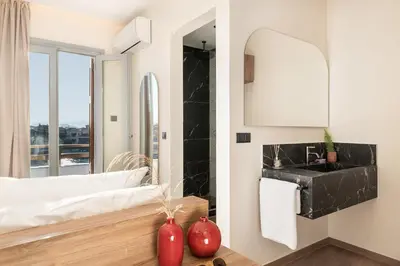 a bathroom with a sink and a mirror at Amphitrite Hotel in Chania Town