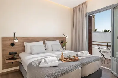 a bedroom with a large bed and a balcony at Amphitrite Hotel in Chania Town