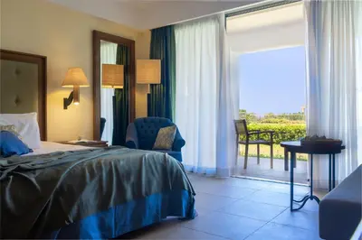a hotel room with a bed and a balcony at Giannoulis – Cavo Spada Luxury Sports & Leisure Resort & Spa in Kolymvari