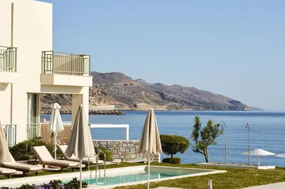 a resort with a pool and chairs and umbrellas at Giannoulis - Grand Bay Beach Resort (Exclusive Adults Only) in Kolymvari