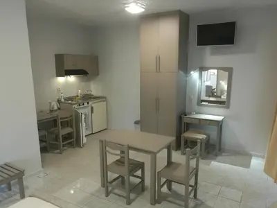 a kitchen with a table and chairs in a room at Niriis Hotel in Kato Daratso