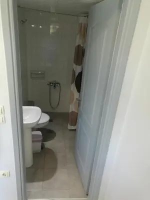 a bathroom with a white toilet and a sink at Niriis Hotel in Kato Daratso