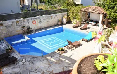 a swimming pool in a yard with chairs at Potoula Apts in Kato Daratso