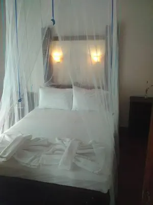 a bed with white sheets and pillows in a room at Potoula Apts in Kato Daratso