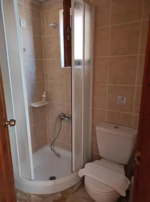a bathroom with a shower and a toilet at Potoula Apts in Kato Daratso