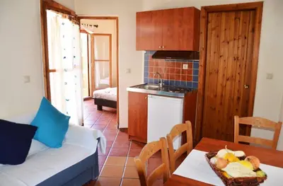a living room with a couch and a table with a bowl of fruit on at Potoula Apts in Kato Daratso