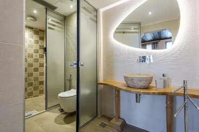 a bathroom with a sink and a toilet and a mirror at Belmondo Hotel in Chania Town