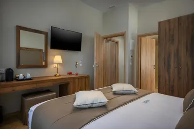 a bedroom with a bed and a desk and a television at Minaret Suites and Apartments in Chania Town