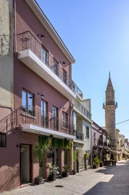 a building with balconies on a street with a tower at Minaret Suites and Apartments in Chania Town