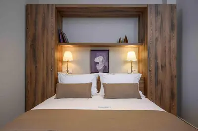 a bedroom with a large bed with a wooden headboard at Minaret Suites and Apartments in Chania Town