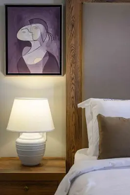 a bedroom with a bed with a lamp and a painting at Minaret Suites and Apartments in Chania Town